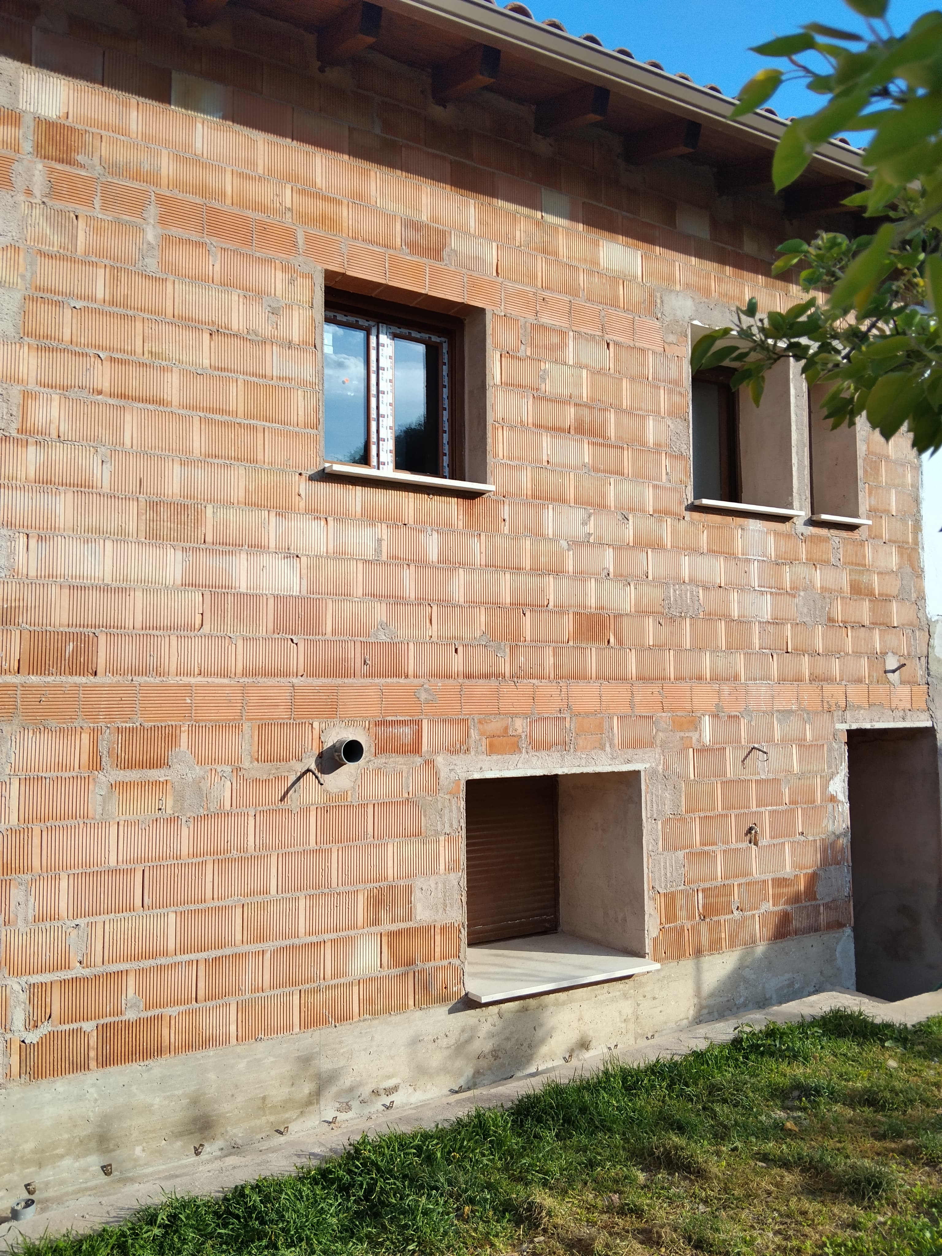 Fachada de ladrillo con huecos y remates preparados